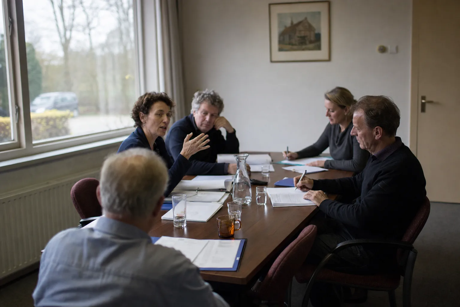 Ondernemer aan tafel met meerdere kopers en adviseurs tijdens een overnamegesprek